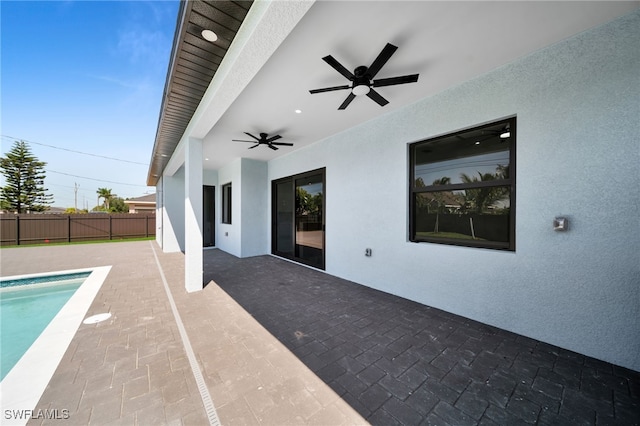 view of swimming pool featuring a ceiling fan, a patio area, a fenced in pool, and fence