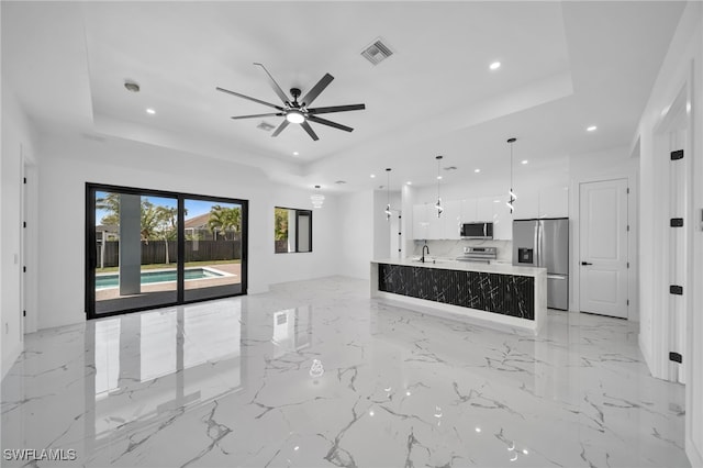 unfurnished living room featuring recessed lighting, visible vents, and a tray ceiling