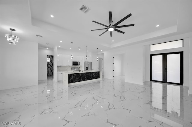 unfurnished living room with recessed lighting, visible vents, and a raised ceiling