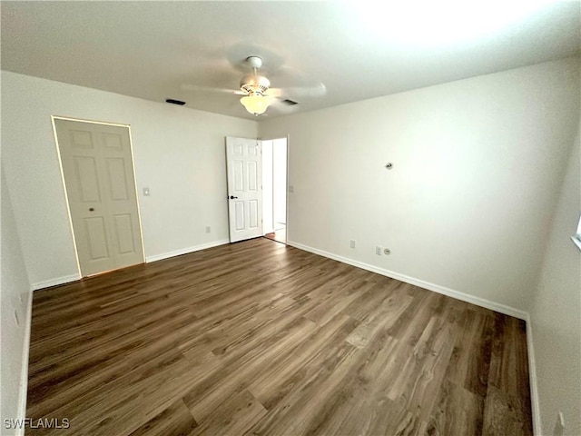 interior space featuring wood finished floors, ceiling fan, baseboards, and visible vents