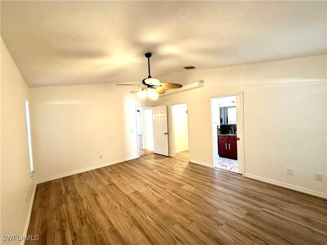 spare room featuring wood finished floors, baseboards, a ceiling fan, and visible vents
