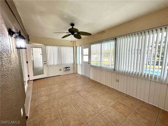unfurnished sunroom featuring a ceiling fan
