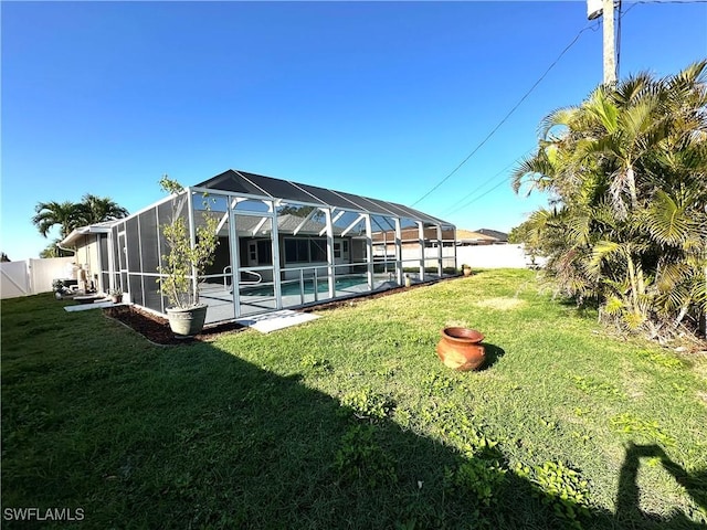 exterior space featuring a fenced backyard, glass enclosure, and a lawn