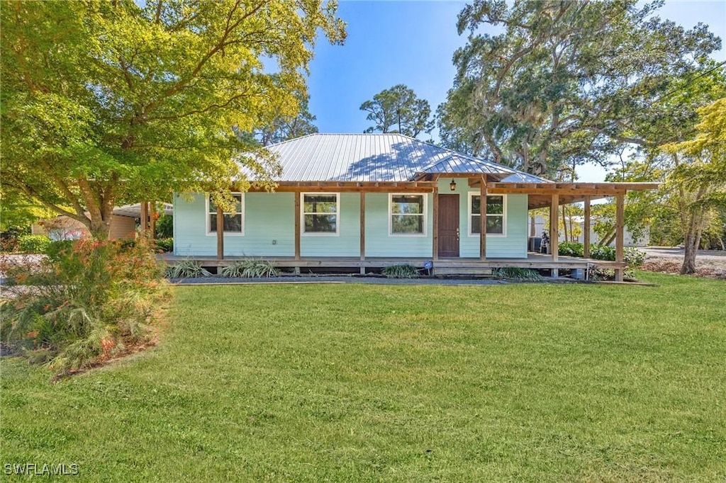 1625 Ft Denaud Rd, Labelle, FL 33935 - rear view of property with a porch, metal roof, and a lawn