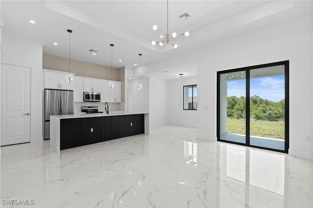 2705 68th St W, Lehigh Acres, FL 33971 - kitchen featuring a center island with sink, a chandelier, appliances with stainless steel finishes, open floor plan, and white cabinetry