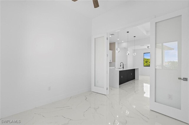 2705 68th St W, Lehigh Acres, FL 33971 - unfurnished room with marble finish floor, baseboards, a ceiling fan, and a sink