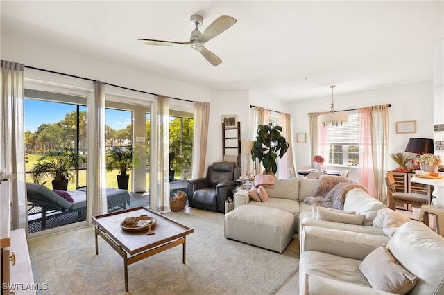 living area with a healthy amount of sunlight and ceiling fan with notable chandelier