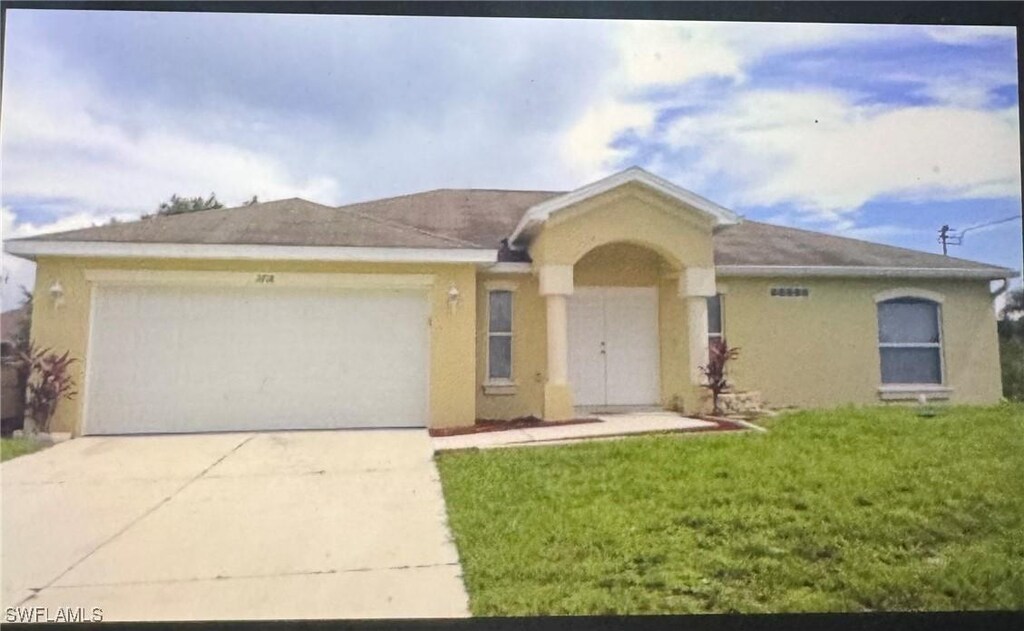 3718 13th St W, Lehigh Acres, FL 33971 - ranch-style house with a garage, stucco siding, concrete driveway, and a front lawn