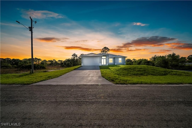 view of front of property with an attached garage, concrete driveway, and a front lawn