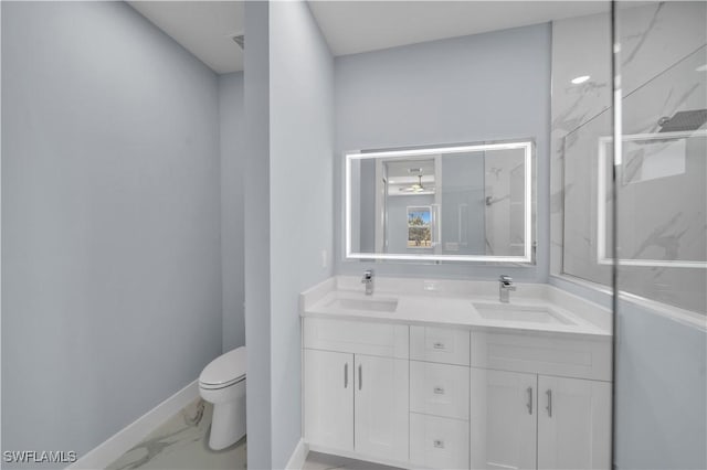 full bath featuring double vanity, marble finish floor, a sink, and toilet