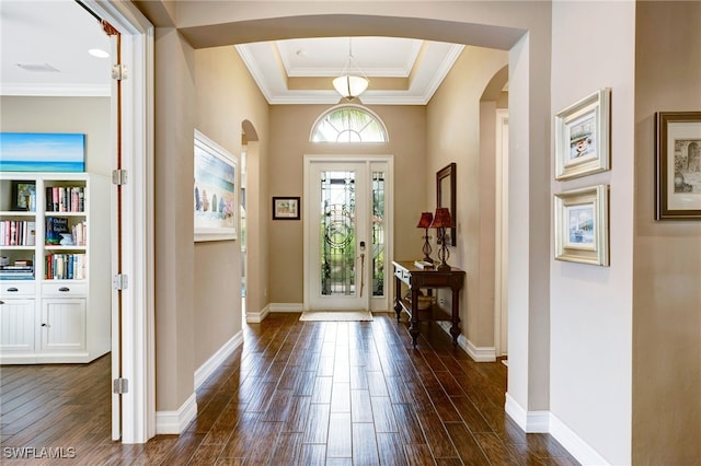 foyer with arched walkways, baseboards, and dark wood finished floors