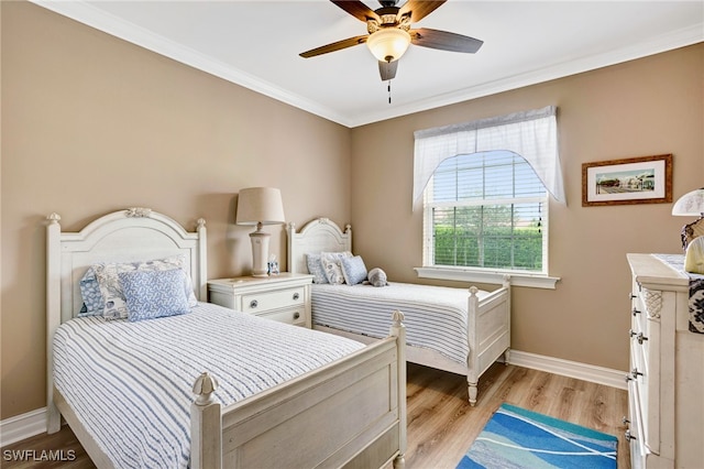 bedroom with light wood finished floors, baseboards, crown molding, and a ceiling fan