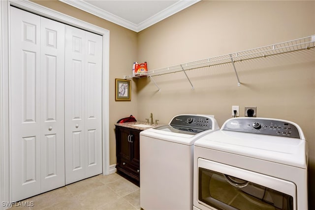 clothes washing area featuring light tile patterned floors, washer and dryer, a sink, ornamental molding, and cabinet space