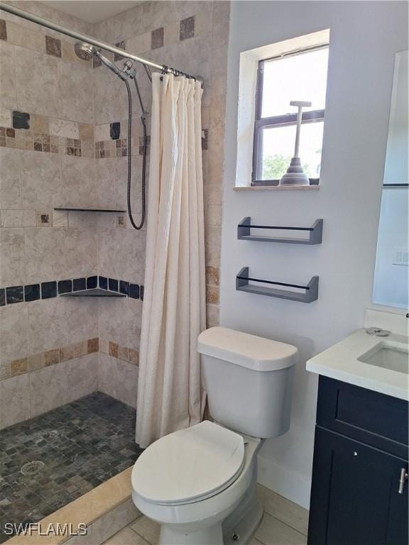 bathroom with a shower stall, tile patterned flooring, vanity, and toilet
