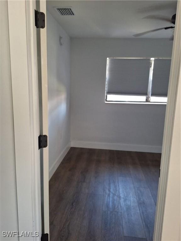 unfurnished room with wood finished floors, ceiling fan, baseboards, and visible vents