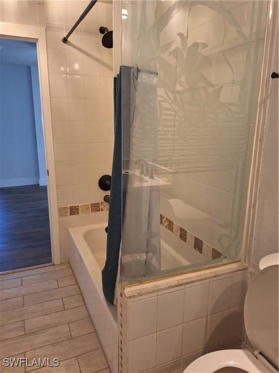 full bath featuring tiled shower / bath and toilet