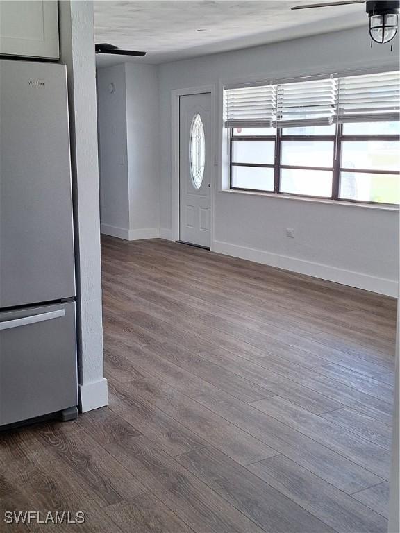 entryway with dark wood-style floors, baseboards, and a ceiling fan