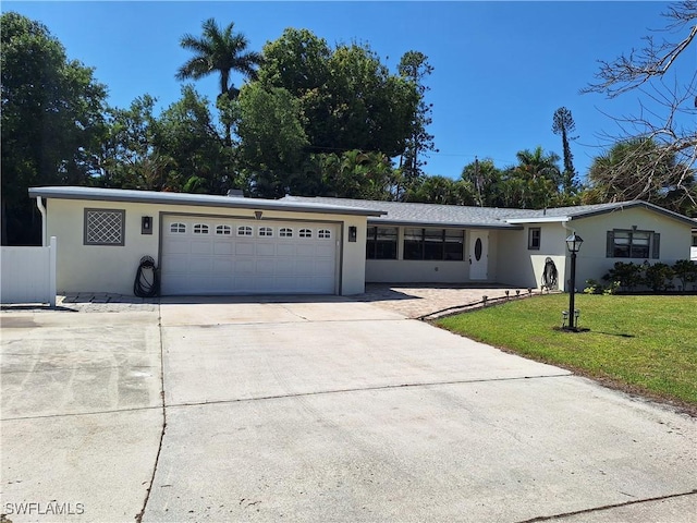 ranch-style home with a garage, a front yard, stucco siding, and concrete driveway