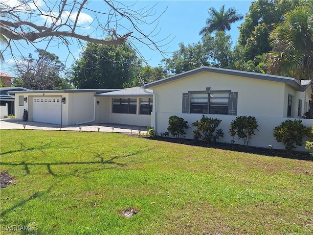 single story home with a front yard, an attached garage, driveway, and stucco siding