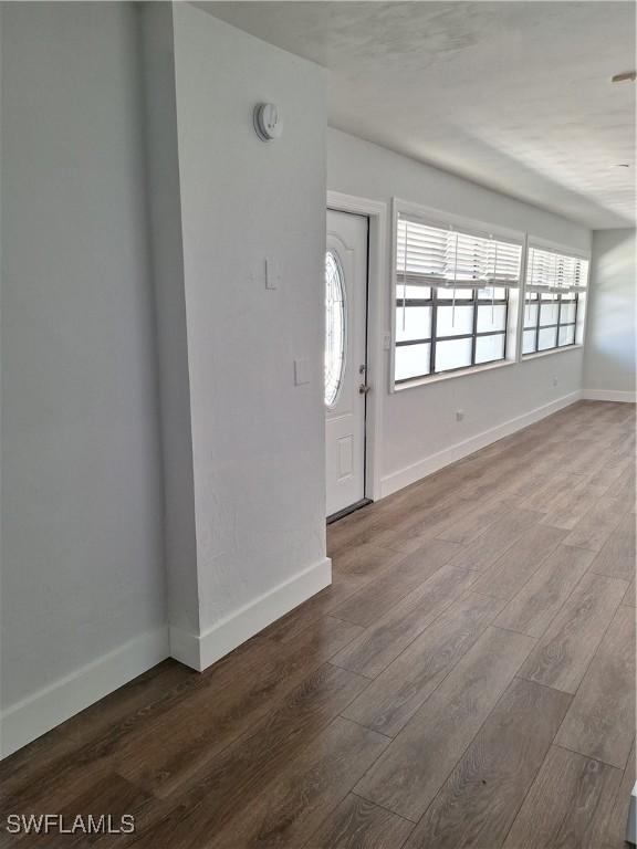 foyer entrance with baseboards and wood finished floors