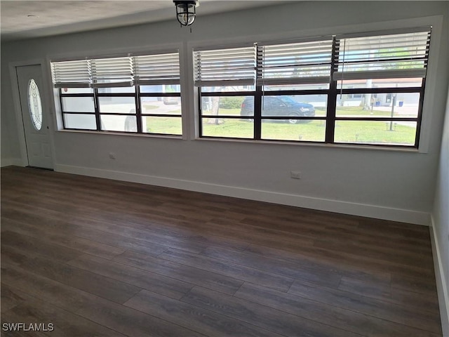 interior space featuring baseboards, dark wood finished floors, and plenty of natural light