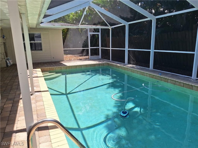 pool featuring a patio area, fence, and glass enclosure