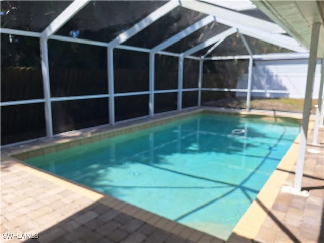 pool with a patio area and glass enclosure