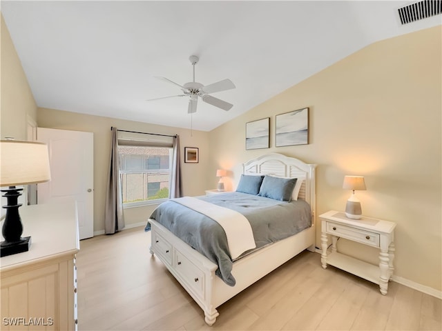 bedroom with light wood-type flooring, baseboards, lofted ceiling, and visible vents