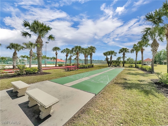 view of community featuring a lawn and shuffleboard