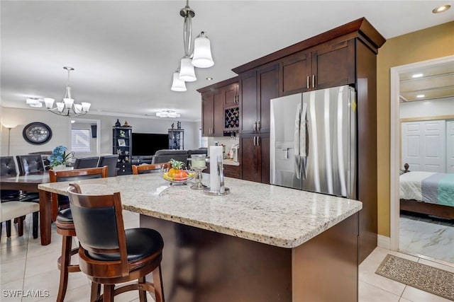 2420 6th Ave SE, Naples, FL 34117 - kitchen with stainless steel refrigerator with ice dispenser, a center island, light stone counters, open floor plan, and decorative light fixtures
