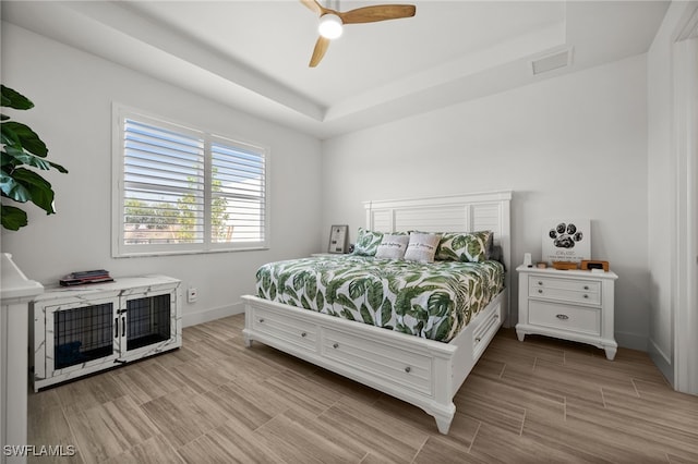 44372 Panther Dr, Punta Gorda, FL 33982 - bedroom with a tray ceiling, baseboards, light wood finished floors, and ceiling fan