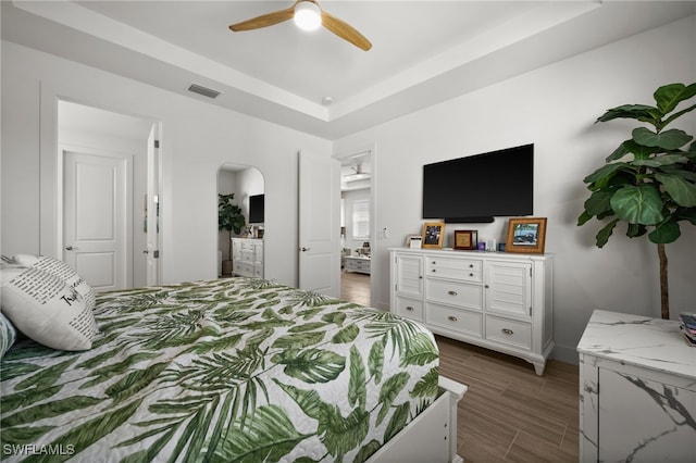 44372 Panther Dr, Punta Gorda, FL 33982 - bedroom featuring visible vents, baseboards, arched walkways, a tray ceiling, and wood finish floors