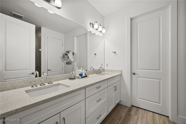 44372 Panther Dr, Punta Gorda, FL 33982 - full bathroom featuring a sink, visible vents, double vanity, and wood finished floors