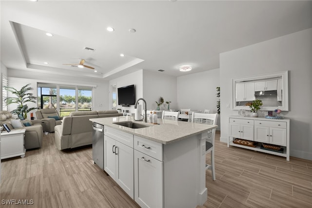 44372 Panther Dr, Punta Gorda, FL 33982 - kitchen with a tray ceiling, white cabinets, a breakfast bar, a sink, and open floor plan