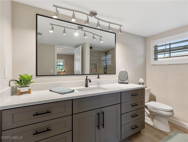 full bathroom with a shower stall, wood finished floors, toilet, and a wealth of natural light