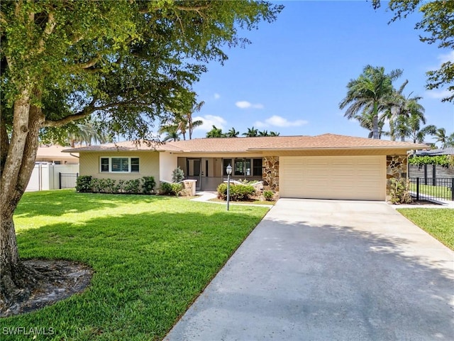 ranch-style house with a garage, a front yard, fence, and concrete driveway