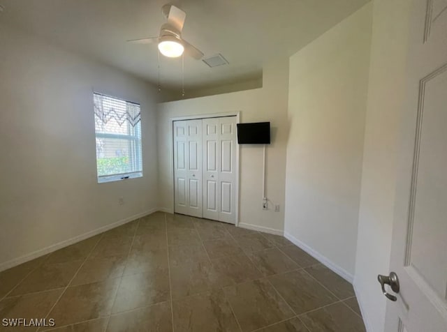 2035 Wellington St, Naples, FL 34120 - unfurnished bedroom featuring tile patterned floors, a closet, baseboards, and a ceiling fan