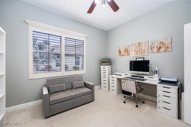 carpeted office with baseboards and a ceiling fan