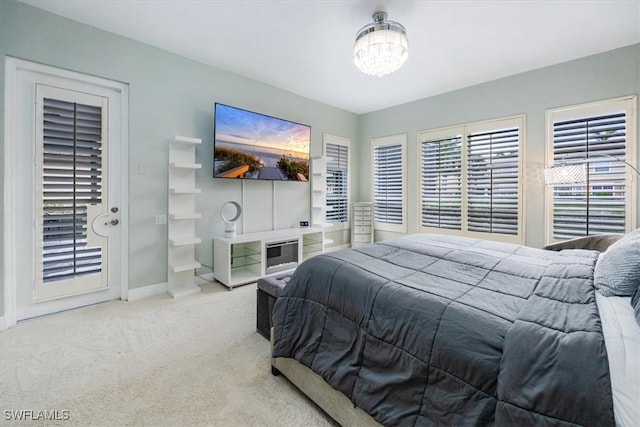 carpeted bedroom with a notable chandelier and baseboards