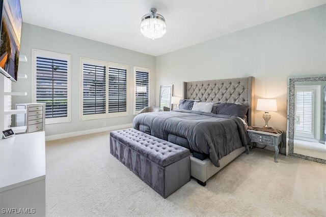 carpeted bedroom with baseboards and a notable chandelier
