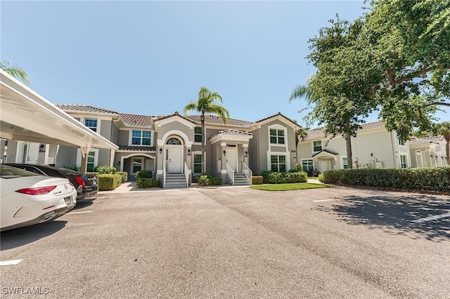 9241 Spring Run Blvd Unit 2202, Estero, FL 34135 - mediterranean / spanish house featuring uncovered parking, a tiled roof, and stucco siding