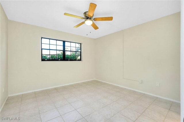 spare room with a ceiling fan and baseboards