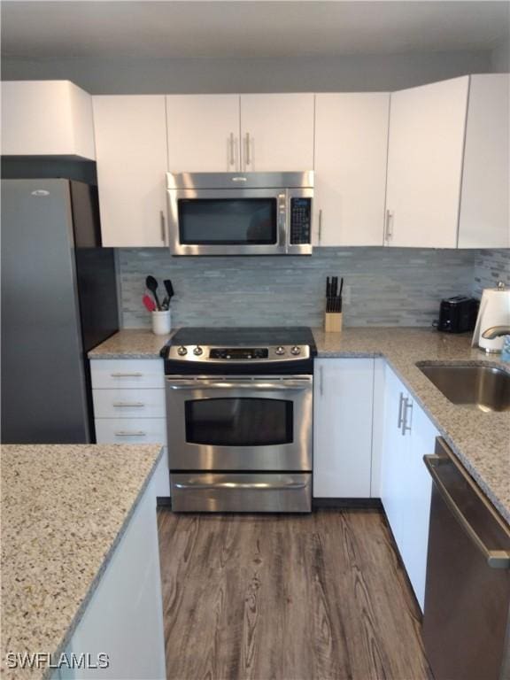 787 106th Ave N, Naples, FL 34108 - kitchen with stainless steel appliances, a sink, white cabinetry, and dark wood-style flooring