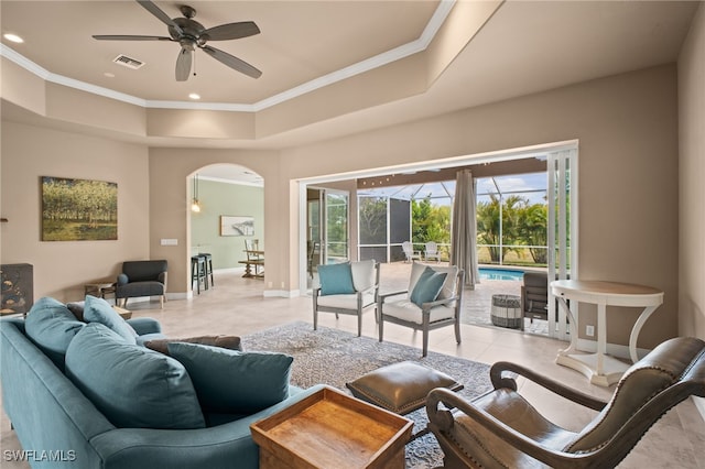 2201 Hampstead Ct, Lehigh Acres, FL 33973 - living area with light tile patterned floors, ceiling fan, a tray ceiling, arched walkways, and ornamental molding