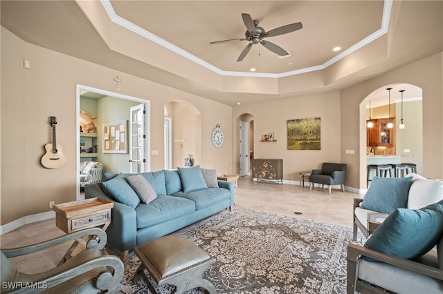 2201 Hampstead Ct, Lehigh Acres, FL 33973 - living area with ceiling fan, a tray ceiling, baseboards, ornamental molding, and arched walkways