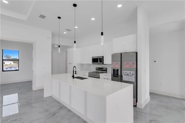 kitchen with a sink, white cabinetry, marble finish floor, and stainless steel appliances