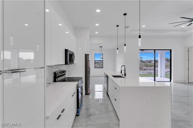 kitchen featuring recessed lighting, white cabinetry, modern cabinets, stainless steel appliances, and a sink