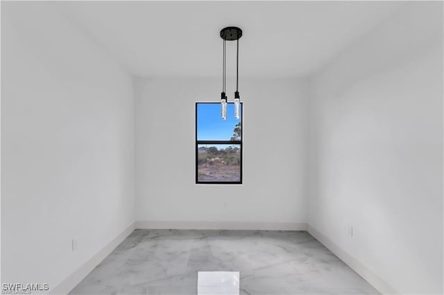 unfurnished dining area featuring baseboards and marble finish floor