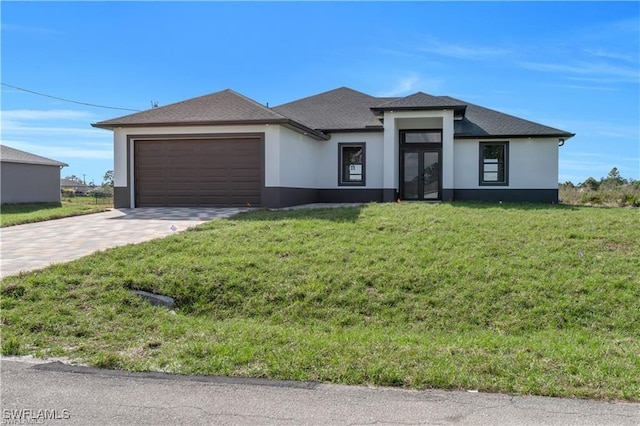 prairie-style home with driveway, stucco siding, a garage, and a front lawn