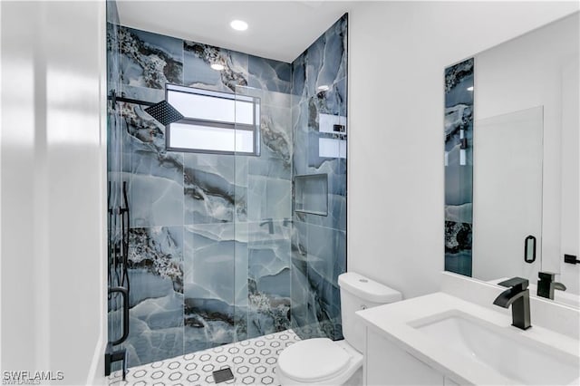 full bath featuring toilet, vanity, and a marble finish shower
